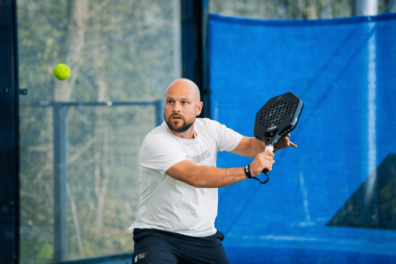 Játékos készenlétben a padelpályán